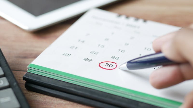 A person scheduling an appointment using a digital calendar booking interface