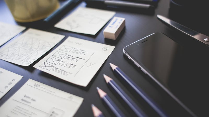 Wireframe and prototype sketches on a designer workspace