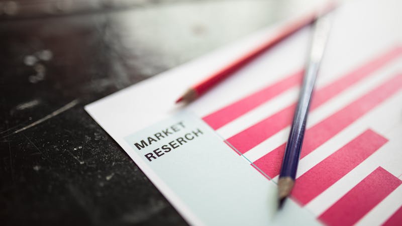 Market research data and competitive analysis charts on a desk