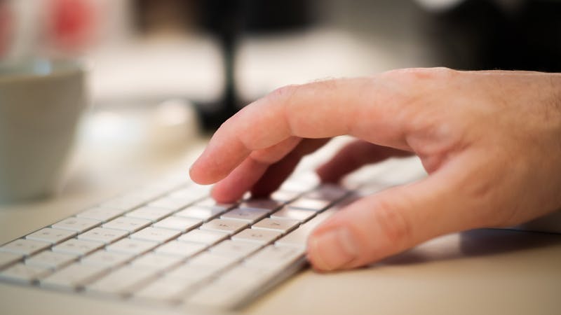 Hands typing on a keyboard navigating a web application
