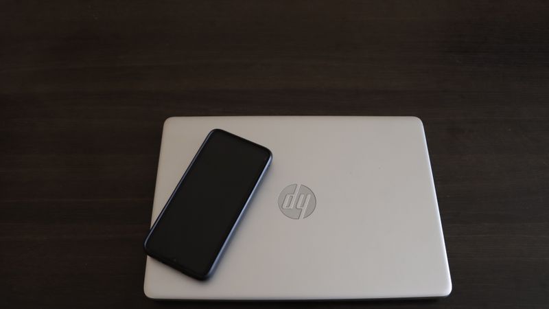Smartphone and laptop side by side showing cross-platform usage